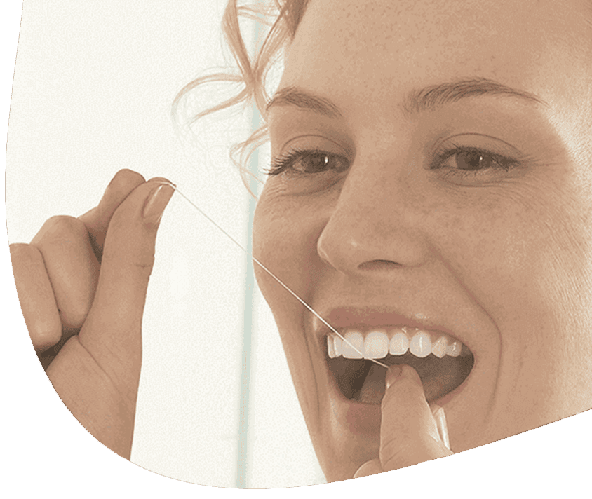 Frau lächelt und reinigt ihre Zähne mit Zahnseide