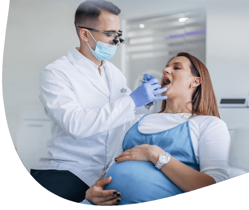 Zahnarzt bei der Reinigung des Mundes einer schwangeren Frau